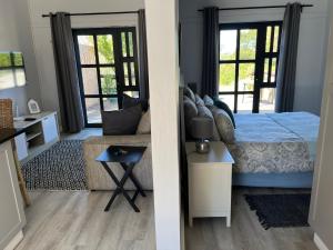a bedroom with a bed and a couch and windows at Stoneridge farm in Plettenberg Bay +107 photos