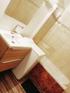 biała łazienka z umywalką i prysznicem w obiekcie SW - Olympic Games Property Paris Bourget w mieście Le Bourget