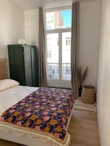 a bedroom with a bed with a quilt on it at Appartement centre ville avec terrasse in Lille