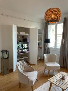 a living room with two chairs and a table at Appartement hyper centre, cathédrale, fibre in Lisieux