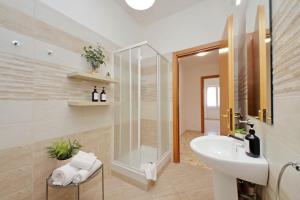 a bathroom with a sink and a glass shower at Ampio con ottimi collegamenti per Roma & Aeroporto in Fiumicino +33 photos