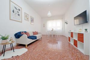 a living room with a white couch and a table at Ampio con ottimi collegamenti per Roma & Aeroporto in Fiumicino
