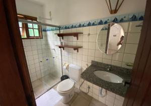 W łazience znajduje się toaleta, umywalka i lustro. w obiekcie Pousada Cantinho do Sossego w mieście Arraial d'Ajuda