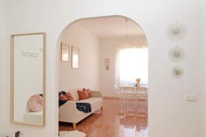 a living room with a white couch and a mirror at Ampio con ottimi collegamenti per Roma & Aeroporto in Fiumicino