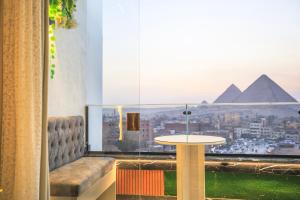 a room with a table and a view of the pyramids at Piccolo Mondo Boutique Hotel in Cairo