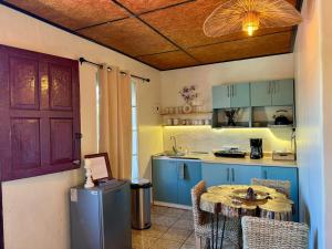 eine Küche mit blauen Schränken und einem Tisch im Zimmer in der Unterkunft Orquídea Loft in Juayúa