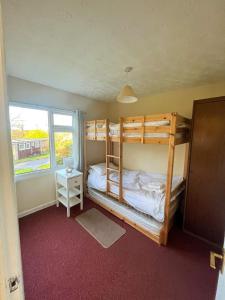 a bedroom with two bunk beds and a window at 15 The Drive, Penstowe Holiday Park, Kilkhampton, Bude, Cornwall in Bude