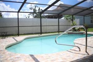 una gran piscina con sombrilla en el patio trasero en NEW Sunny Escape! Enjoy TV by your Private Pool Mins from Disney, en Davenport