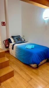 - une chambre avec un lit et une couverture bleue dans l'établissement Rincón Estelles, à Estella