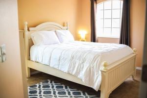 ein Schlafzimmer mit einem weißen Bett mit einem Fenster in der Unterkunft NEW Disney World Villa 4BR, Private Pool Fam Retreat in Davenport + 36 Fotos