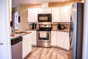 a kitchen with white cabinets and stainless steel appliances at NEW Sunny Escape! Enjoy TV by your Private Pool Mins from Disney in Davenport