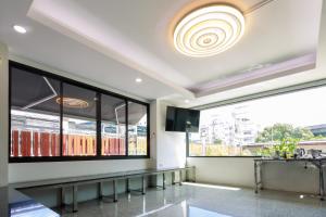 una sala d'attesa con ampie finestre e una TV di Siam Rama9 Hotel a Amphoe Phra Khanong