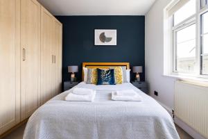 a bedroom with a large bed with blue walls at The Tower Bridge Collection in London