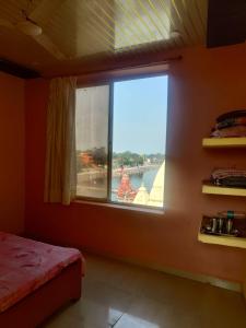 Kailash kuti Guest House في اوجاين: غرفة نوم مع نافذة مطلة على الماء