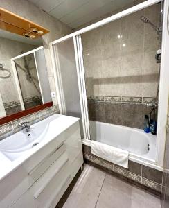 uma casa de banho com uma banheira e um lavatório e uma banheira em Apartment Sagrera em Barcelona