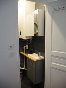 a small kitchen with a sink and white cabinets at 2 Pièces avec Balcon Plein Sud in Paris