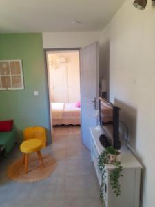 ein Wohnzimmer mit einem TV und ein Zimmer mit einem Bett in der Unterkunft La Micalene in Trans-en-Provence