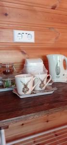 a shelf with three cups and plates on it at Gasthof Zum Lugauer in Radmer an der Hasel