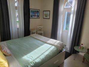 a bedroom with a bed and a window at La Roseraie in Neuville-de-Poitou