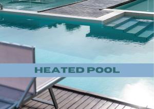 a heated pool with a bench and the words heated pool at Domino Suite Hotel & Residence in Lido di Jesolo