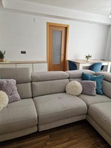 a living room with a couch with pillows on it at Quarto com banheiro privado em apartamento familiar in Alicante