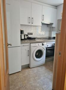 a kitchen with a washing machine and a washer at Quarto com banheiro privado em apartamento familiar in Alicante