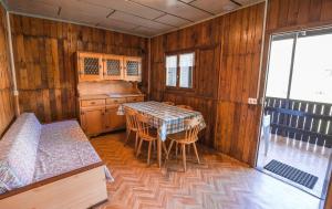 a kitchen with a table and chairs in a room at Bungalow al Lago in Ledro
