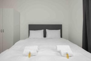 een wit bed met twee witte handdoeken erop bij Urban Oasis with Queen Bed and View BE-42 in Zürich