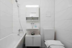 um banheiro branco com uma pia e uma banheira em Urban Oasis with Queen Bed and View BE-42 em Zurique