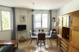 sala de estar con mesa, sillas y TV en Queyries - Appartement 2 chambres avec Parking en Burdeos