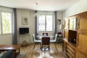 salon ze stołem, krzesłami i telewizorem w obiekcie Queyries -2 chambres Parking Ascenseur Balcon Rive Droite w mieście Bordeaux