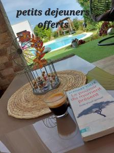 een boek en een drankje op een tafel met een boek bij Chez Cendra in Borgo