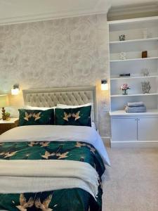 um quarto com uma cama com lençóis verdes e brancos em Flat in the heart of Holland Park em Londres