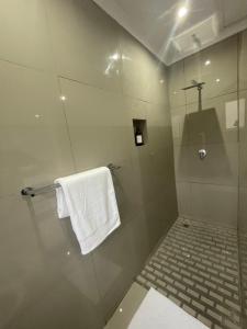 W łazience znajduje się prysznic i biały ręcznik. w obiekcie Trendy, Comfortable 1 bedroom Apartments in Mthatha w mieście Mthatha