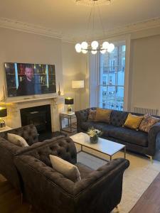 uma sala de estar com dois sofás e uma televisão em Flat in the heart of Holland Park em Londres