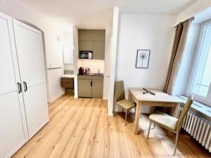a room with a table and chairs and a kitchen at Heart of Zurich Modern Studio HG7 in Zurich