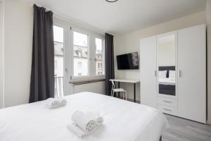 a white bedroom with a bed with towels on it at Urban Oasis with Queen Bed and View BE-44 in Zürich