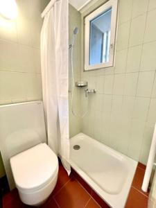 a white bathroom with a toilet and a shower at Heart of Zurich Modern Studio HG7 in Zurich