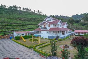 una casa con parco giochi di fronte a una collina di Mystique stay resort a Kotagiri