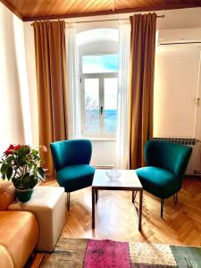 sala de estar con 2 sillas verdes y mesa en Apartment Riva, en Makarska