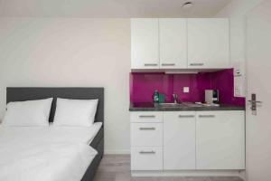 1 dormitorio con armarios blancos y cocina púrpura en Urban Oasis with Queen Bed and View BE-29 en Zúrich