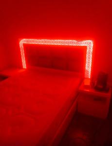 a red bedroom with a bed with a head board at Appartement moyen standing in Inezgane