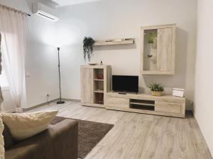 uma sala de estar com um sofá e uma televisão de ecrã plano em Station House em Lido di Ostia