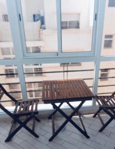 a table and two chairs in front of a window at Appartement moyen standing in Inezgane