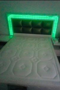 a bed with a green light on top of it at Appartement moyen standing in Inezgane