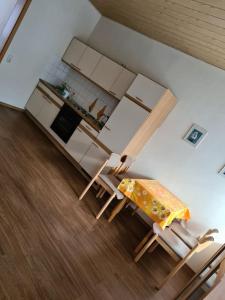 uma cozinha com mesa e cadeiras num quarto em Gemütliche Ferienwohnung am Waldrand em Elgersburg