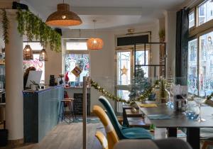 restauracja ze stołem, krzesłami i oknami w obiekcie Celenya Hôtel w mieście Tulon