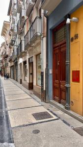 an empty street with a brown door on a building at Rincón Estelles in Estella
