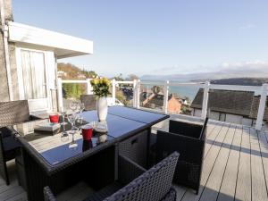 Un patio con una mesa y sillas en una terraza. en 11 Glyn Garth Mews, en Llandegfan