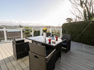 a patio with a table and chairs on a deck at 11 Glyn Garth Mews in Llandegfan